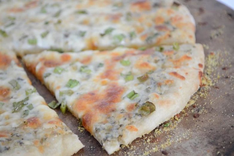 Slicing up White Spinach and Parmesan Pizza